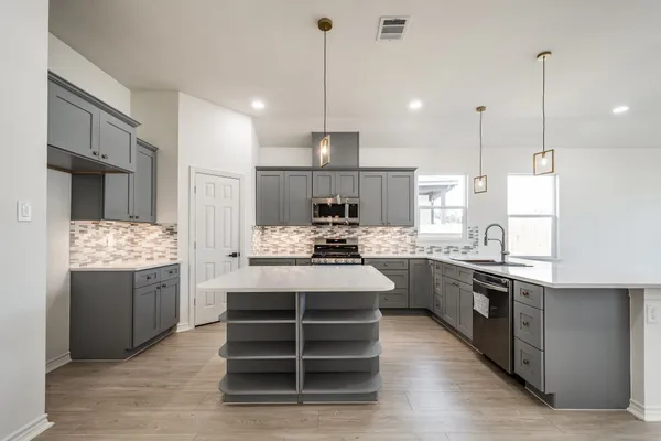 a kitchen with kitchen island a stove a sink and a refrigerator