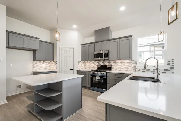 a kitchen with stainless steel appliances a stove sink and microwave