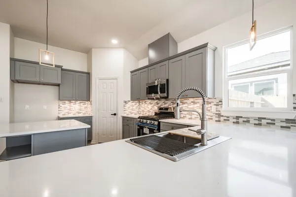 a kitchen with a sink stove and wooden floor