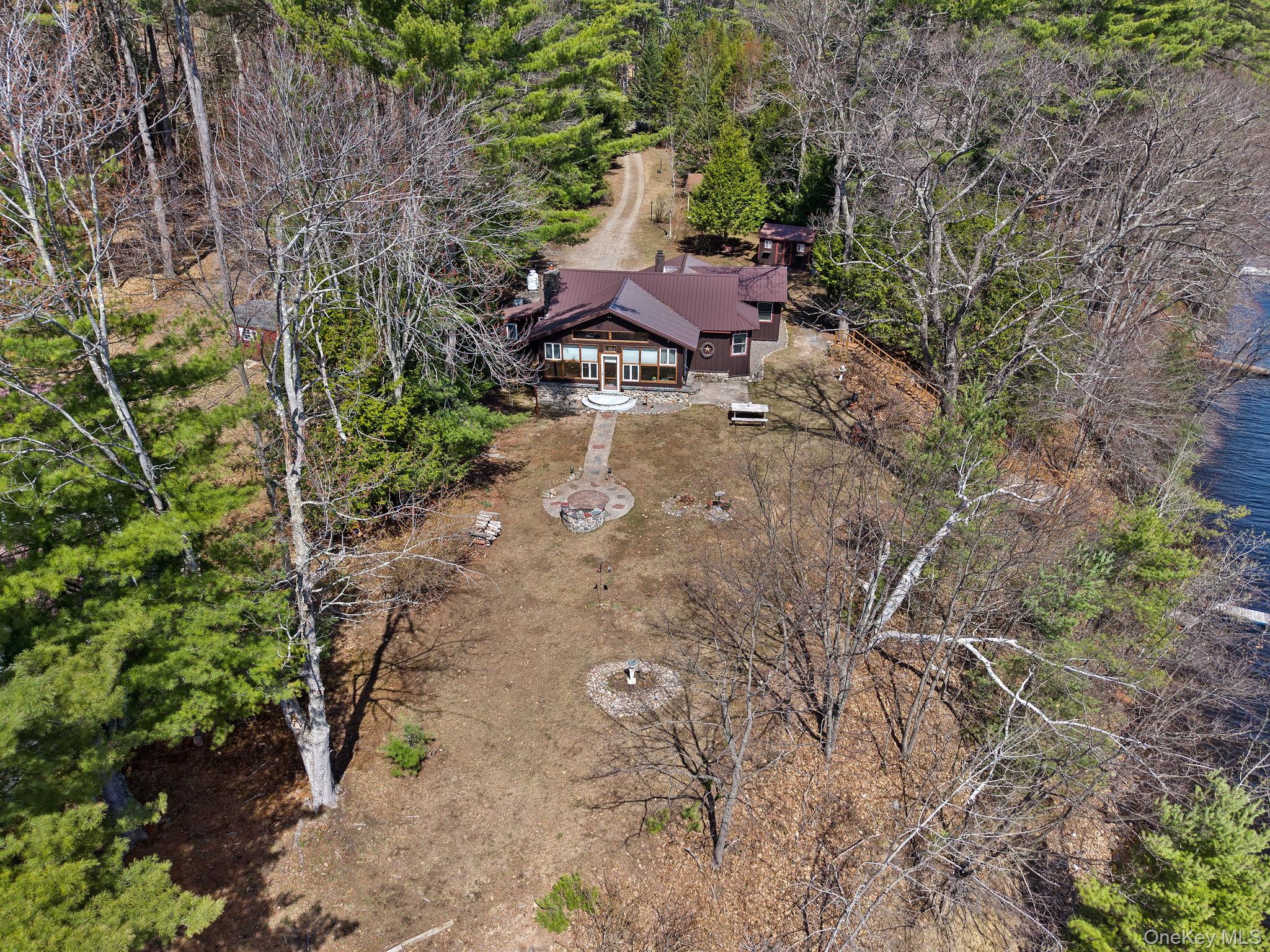 866 North Shore Road Hadley, NY 12835 - Photo 6 of 50 Rear yard space featuring entertainment possibilities, firepit and multiple sitting areas.