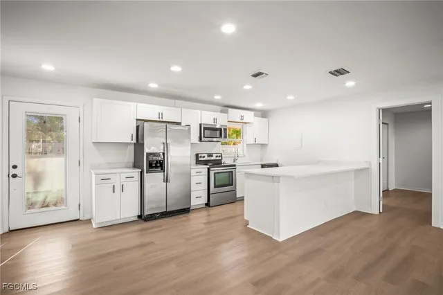 a kitchen with stainless steel appliances kitchen island wooden cabinets and refrigerator