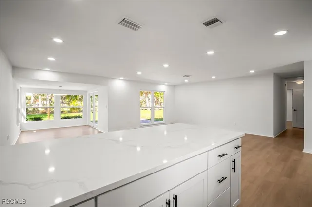 a view of kitchen with kitchen island white cabinets and refrigerator