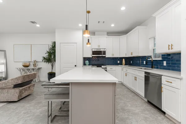a kitchen with stainless steel appliances kitchen island granite countertop a sink and cabinets