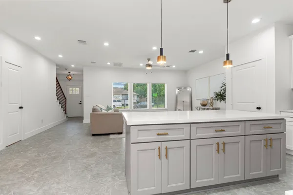 a kitchen with white cabinets and sink