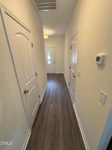 a view of a hallway with wooden floor and staircase