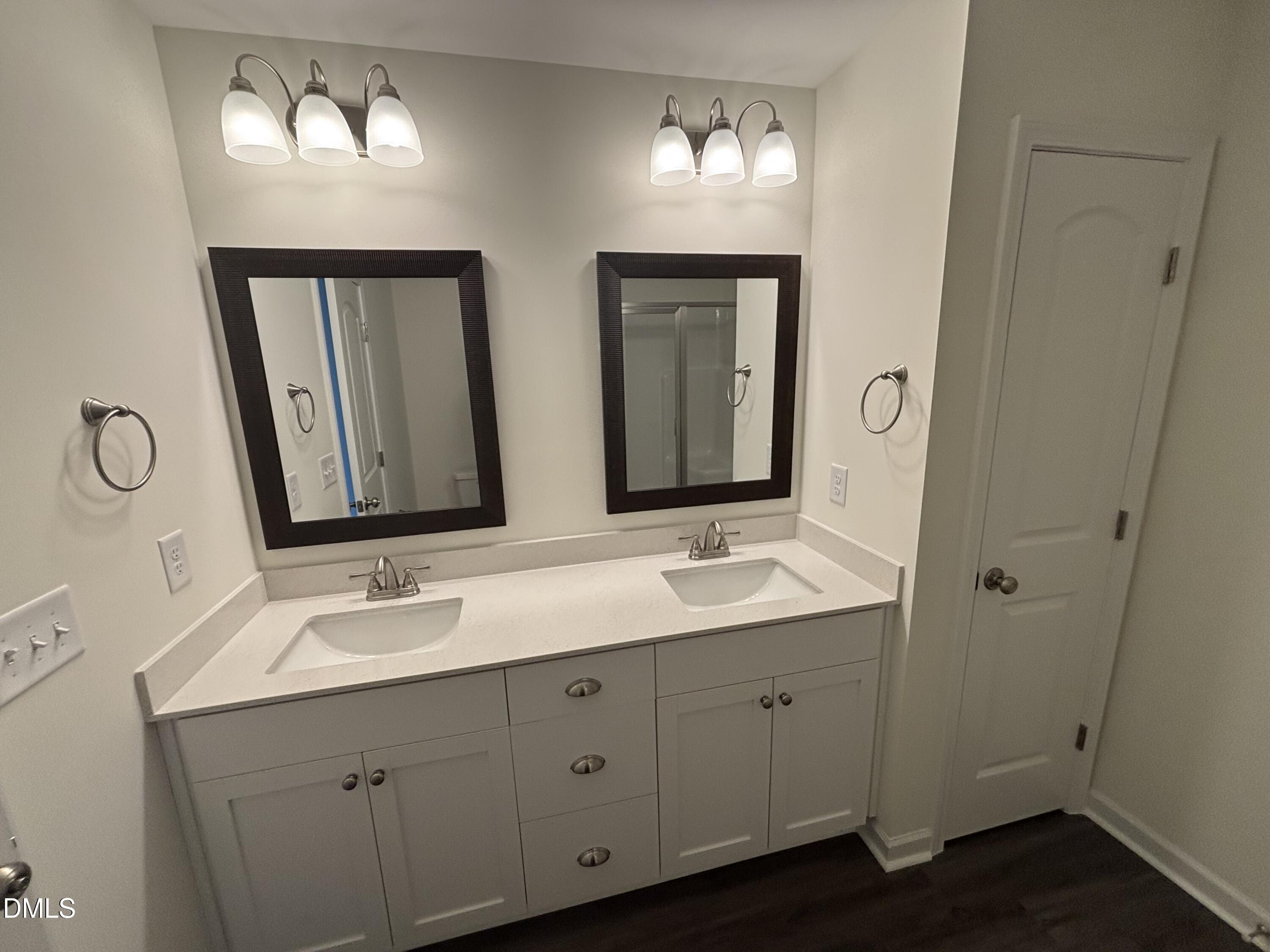 606 South Blackmon Street Benson, NC 27504 - Photo 17 of 25 a bathroom with a double vanity sink and a mirror