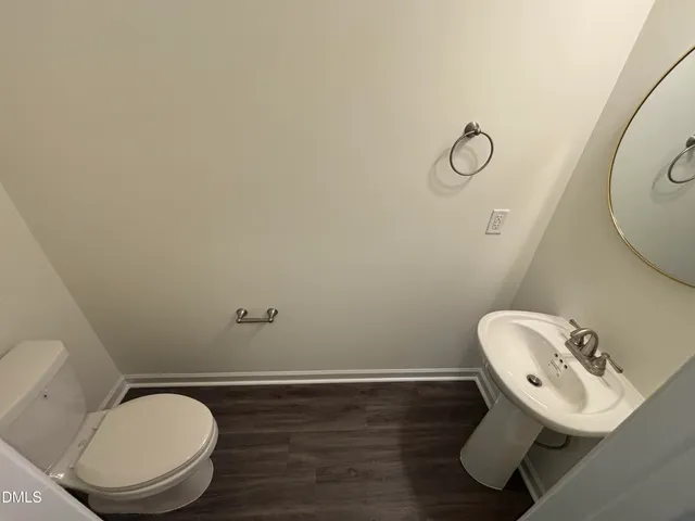 a bathroom with a toilet mirror and sink
