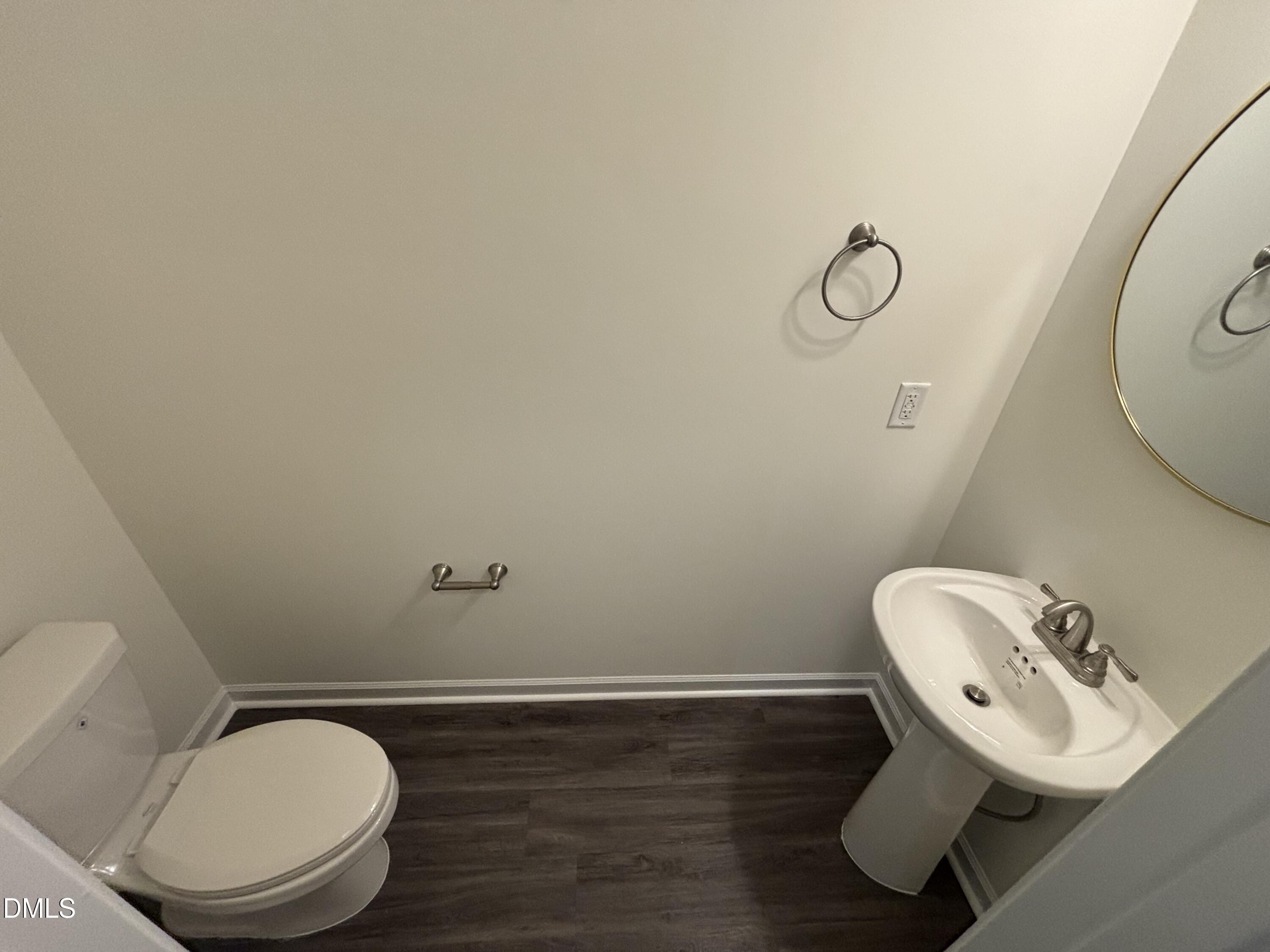 606 South Blackmon Street Benson, NC 27504 - Photo 4 of 25 a bathroom with a toilet mirror and sink