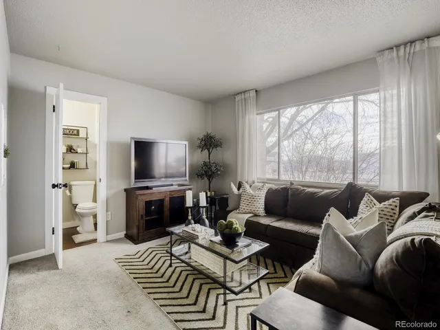 a living room with furniture a large window and a flat screen tv
