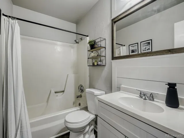 a bathroom with a granite countertop sink toilet and shower