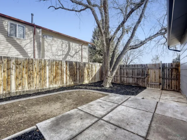 a view of a backyard with wooden fence