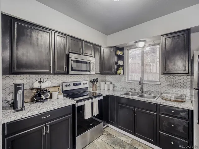 a kitchen with stainless steel appliances granite countertop a sink stove and microwave