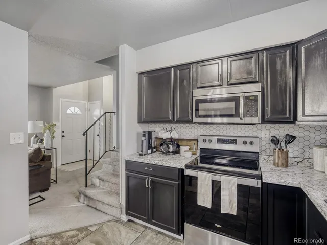 a kitchen with stainless steel appliances a stove sink microwave and cabinets