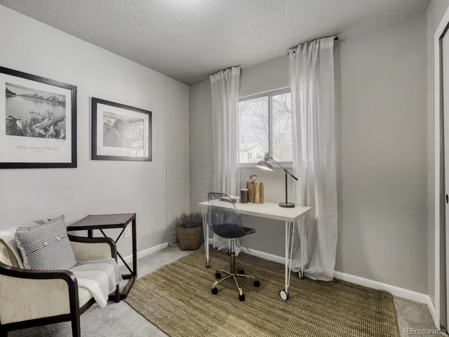 a view of a workspace with furniture and a window