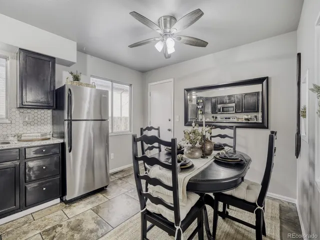 a kitchen with stainless steel appliances granite countertop a dining table and chairs