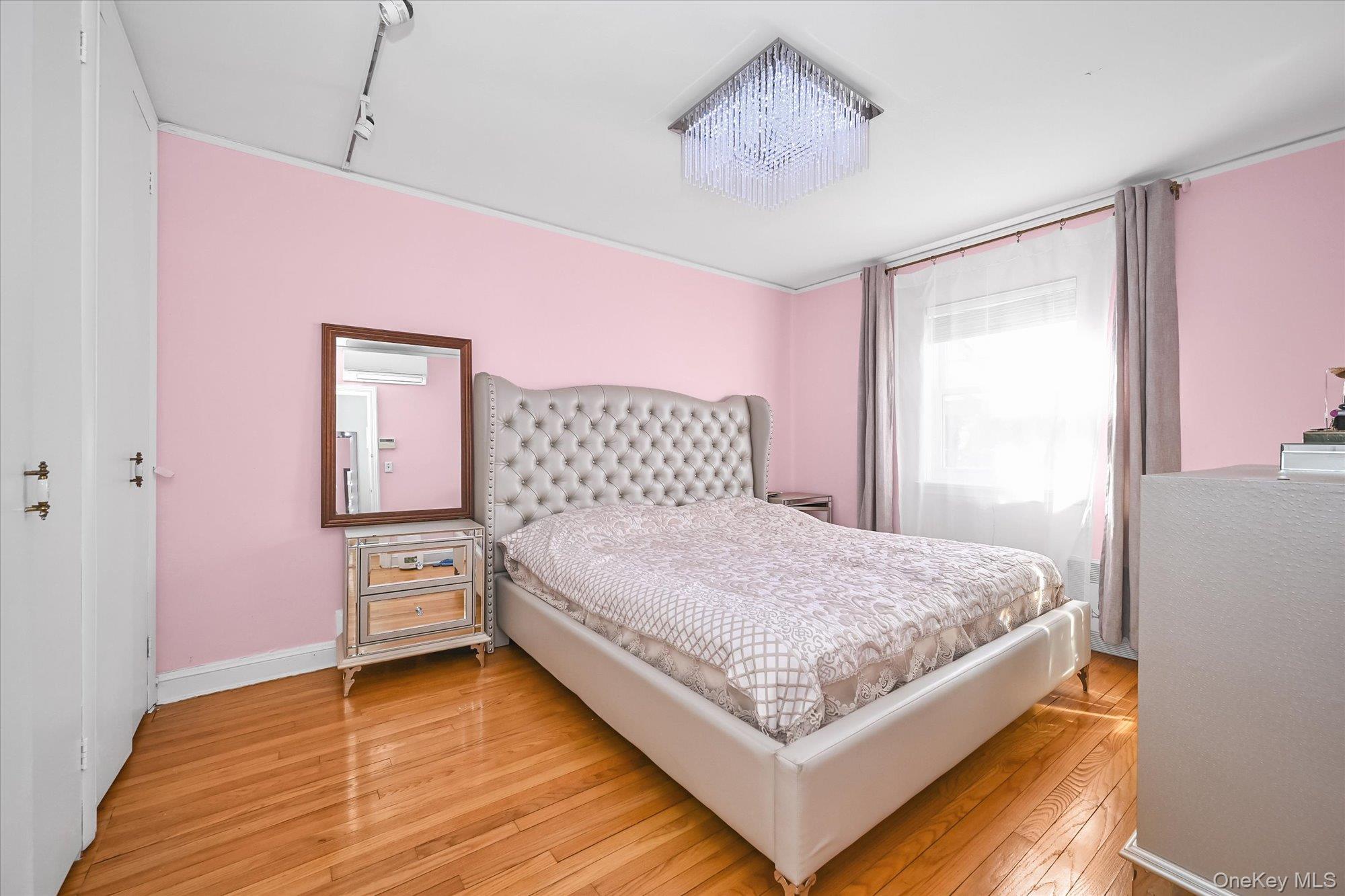 184-32 Cambridge Road Queens, NY 11432 - Photo 12 of 22 a bedroom with a bed and a chandelier