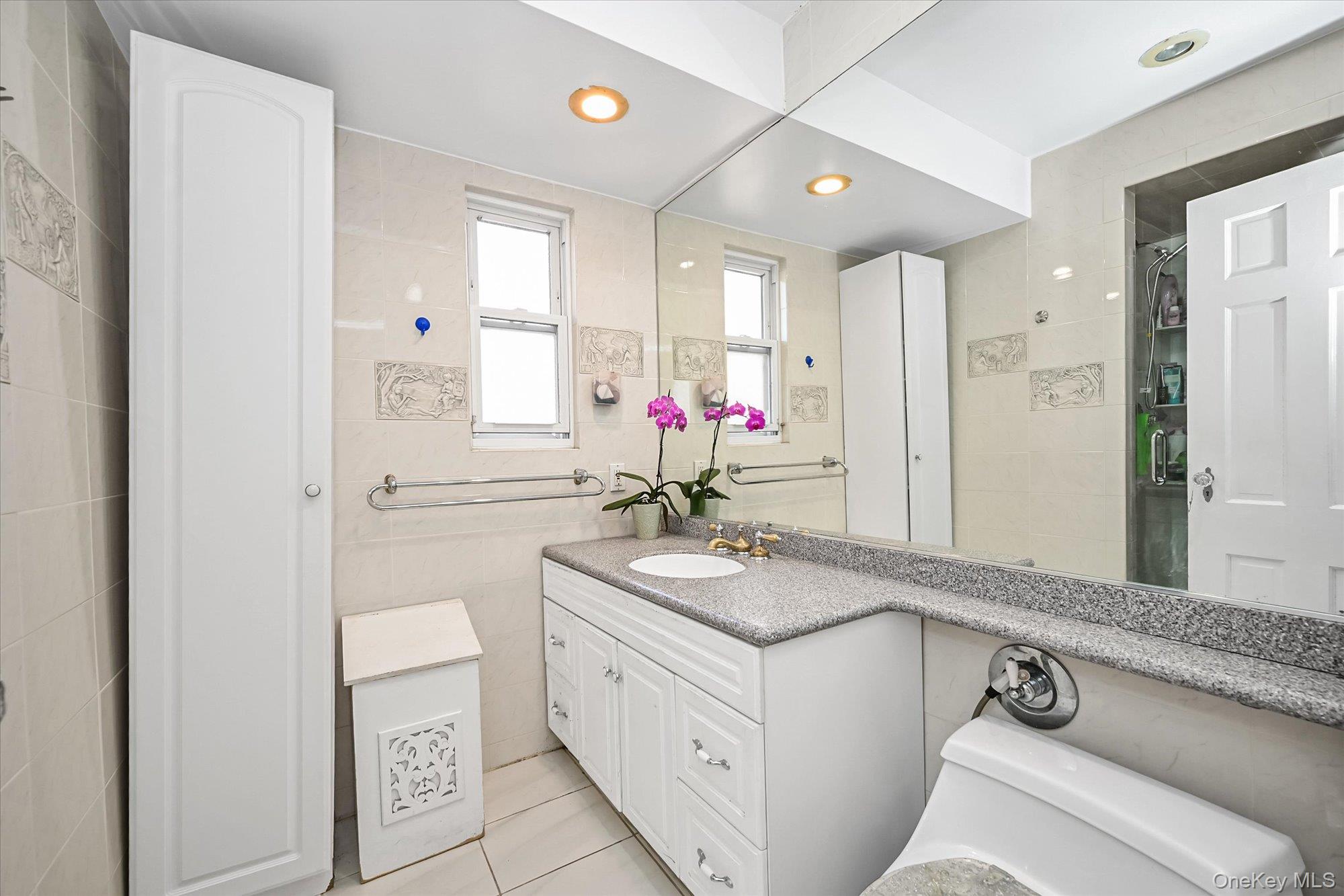 184-32 Cambridge Road Queens, NY 11432 - Photo 14 of 22 a bathroom with a granite countertop sink a mirror and a shower