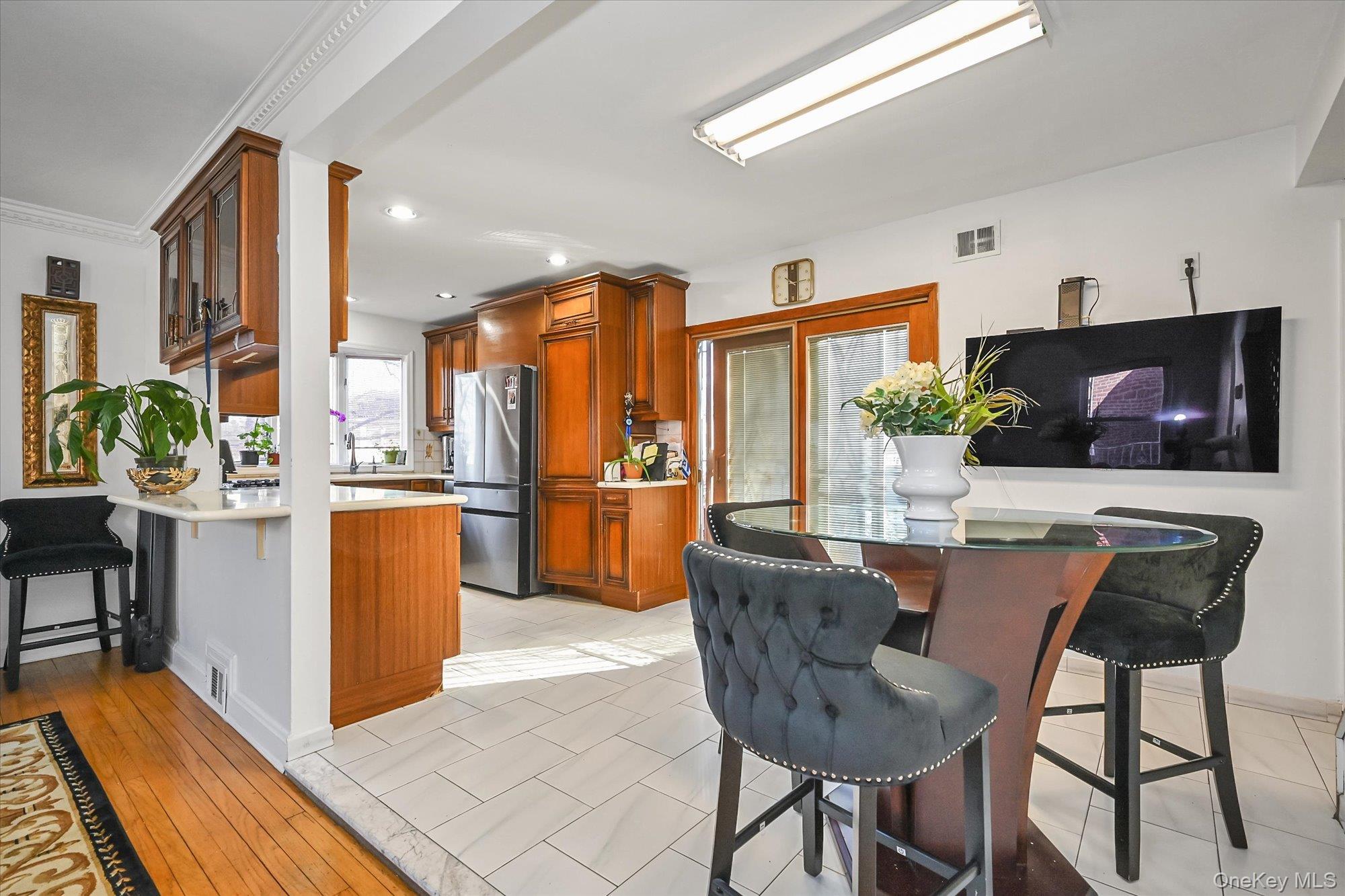 184-32 Cambridge Road Queens, NY 11432 - Photo 8 of 22 a dining room with furniture a chandelier and a flat screen tv