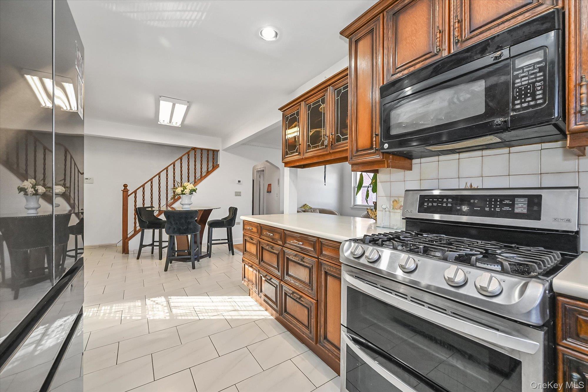 184-32 Cambridge Road Queens, NY 11432 - Photo 9 of 22 a kitchen with wooden cabinets and a stove top oven