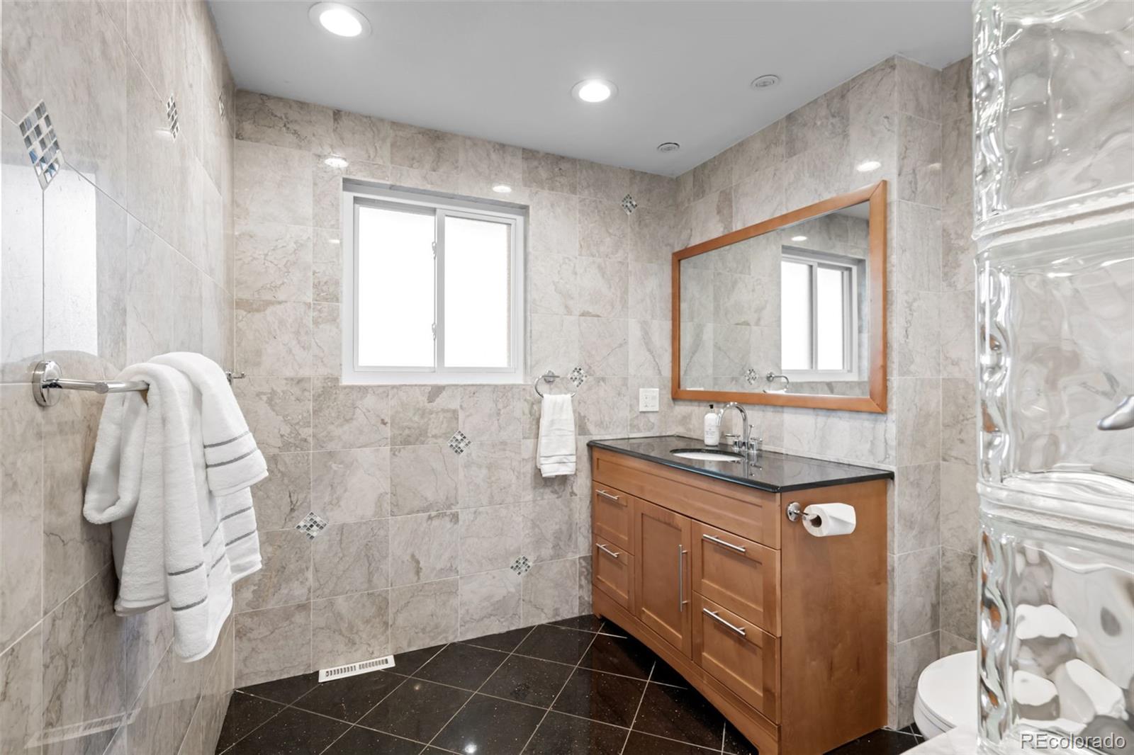 210 South Deframe Way Golden, CO 80401 - Photo 30 of 50 a bathroom with a granite countertop sink a mirror and a shower
