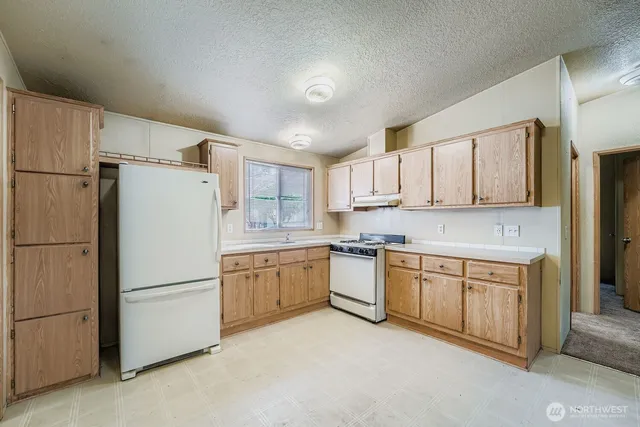 a kitchen with white cabinets and white appliances