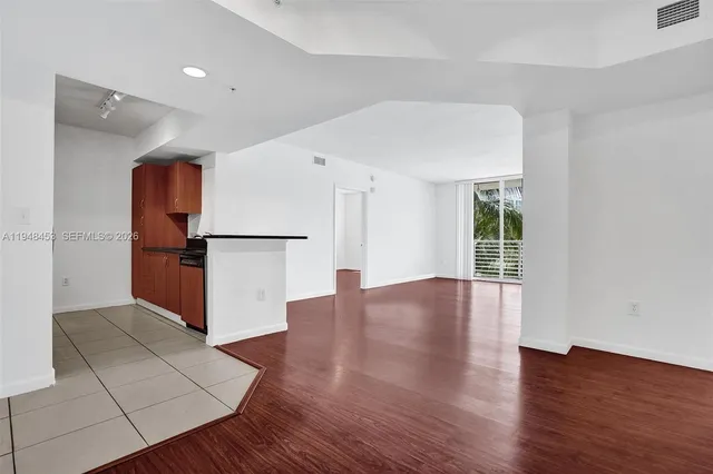 a view of a kitchen with wooden floor and a refrigerator
