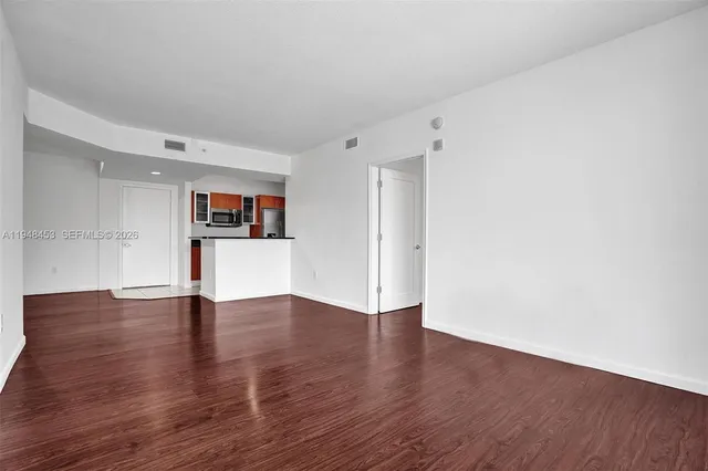 a view of empty room with wooden floor