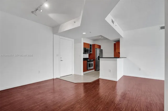 a view of an empty room with wooden floor