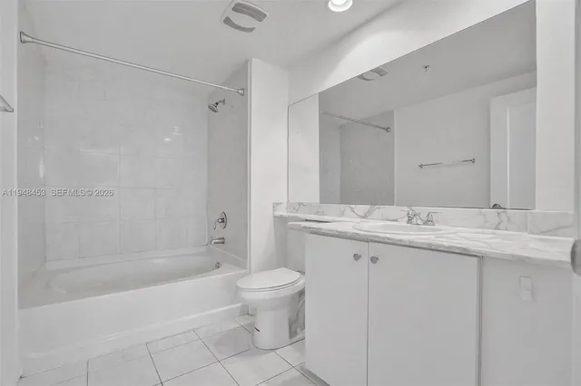 a bathroom with a granite countertop sink a toilet and shower