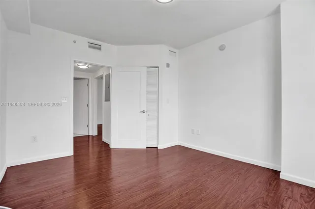 a view of an empty room with wooden floor