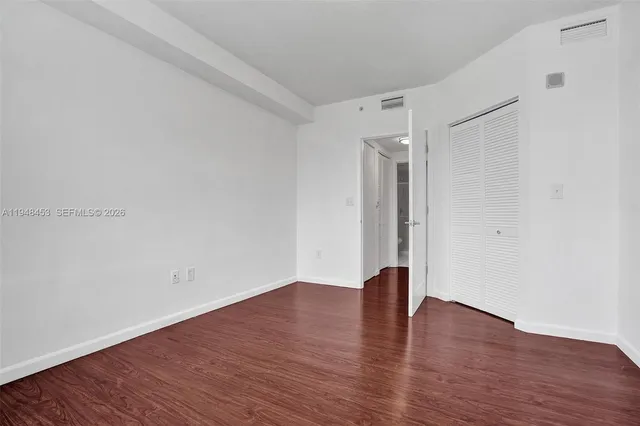 a view of empty room with wooden floor