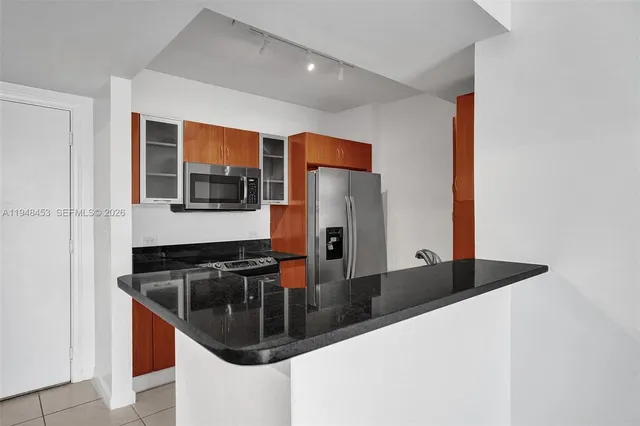 a kitchen with stainless steel appliances granite countertop a sink and a refrigerator