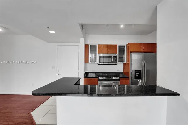 a kitchen with stainless steel appliances granite countertop a sink and a stove