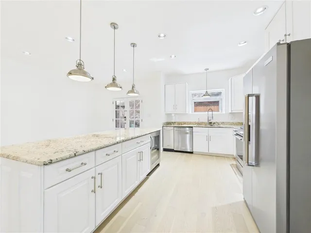 a kitchen with white cabinets and white appliances