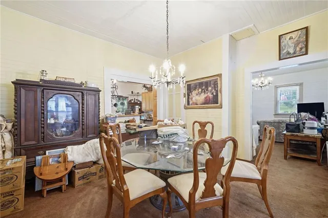 a dining room with furniture a chandelier and wooden floor