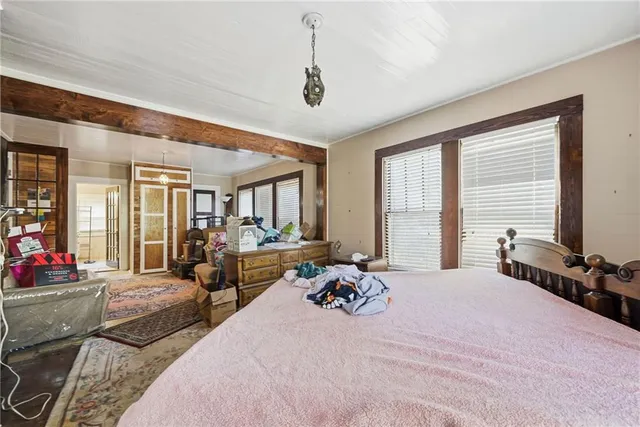 a bedroom with a bed large window and couch