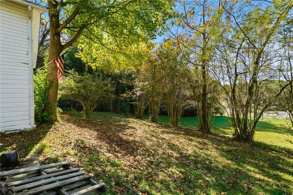 a backyard of a house with large trees and barbeque oven