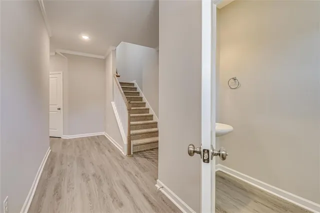 a view of a hallway with wooden floor and staircase
