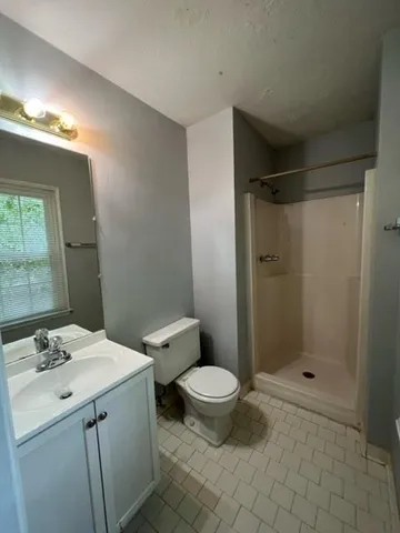 a bathroom with a granite countertop sink toilet and shower