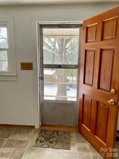 a view of a room with wooden floor and a bathroom