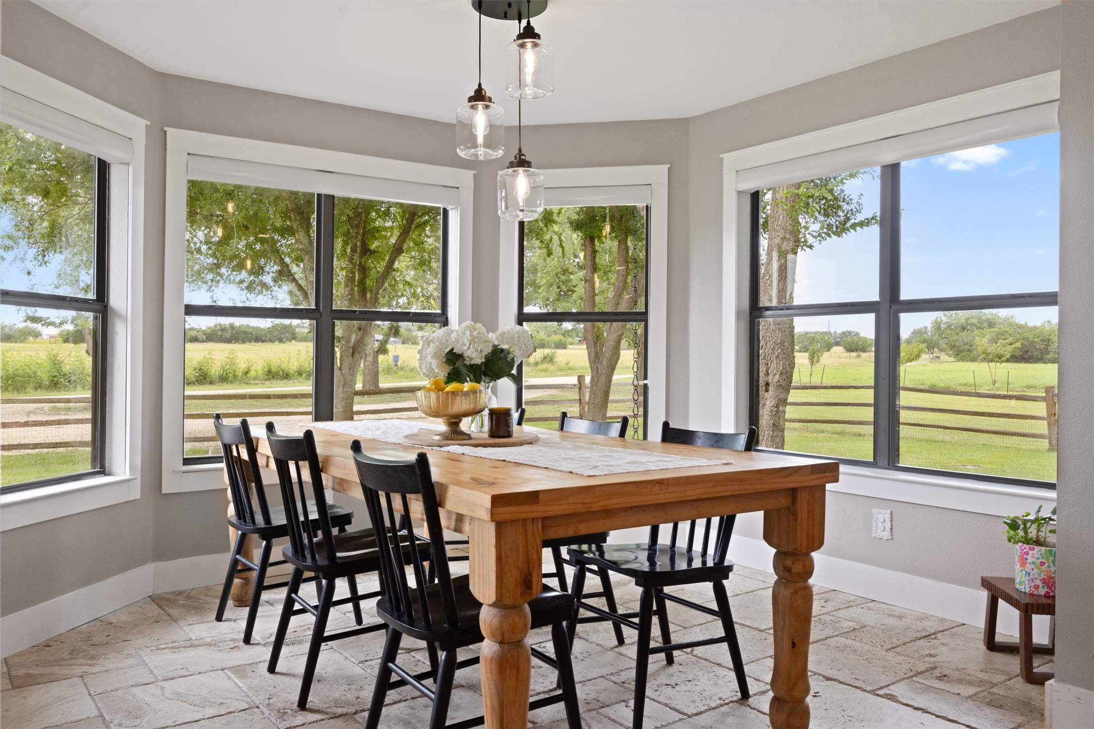 13590 Ranch Road 2338 Georgetown, TX 78633 - Photo 5 of 39 Dining area off the kitchen - plenty of room for a large table and family gatherings! Travertine tiled floors and 8 large bay windows look towards the front of the property.