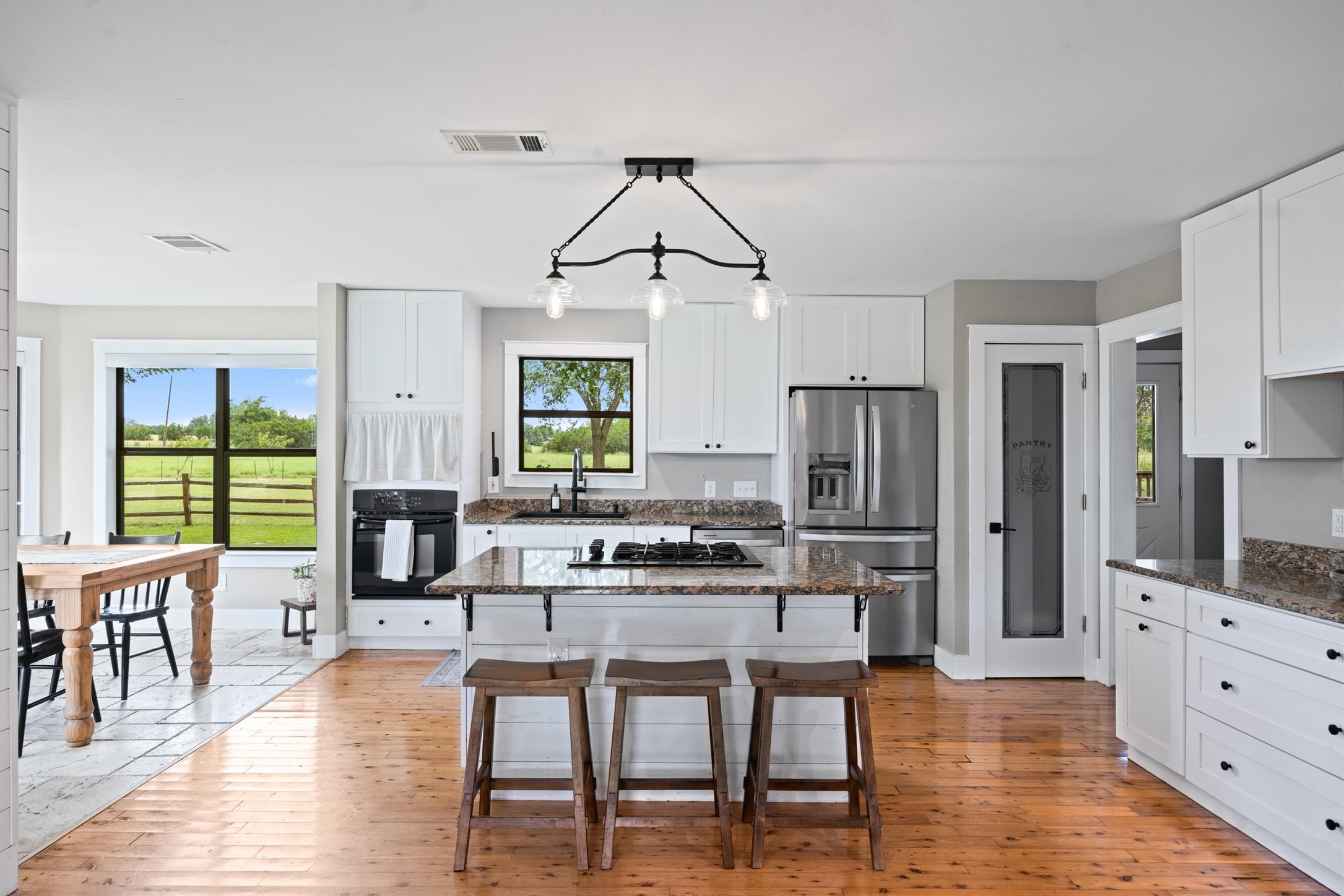 13590 Ranch Road 2338 Georgetown, TX 78633 - Photo 10 of 39 Another view of kitchen and dining areas. Pantry is the door to the right of the refrigerator. To the right of that leads to more storage and mud room area.