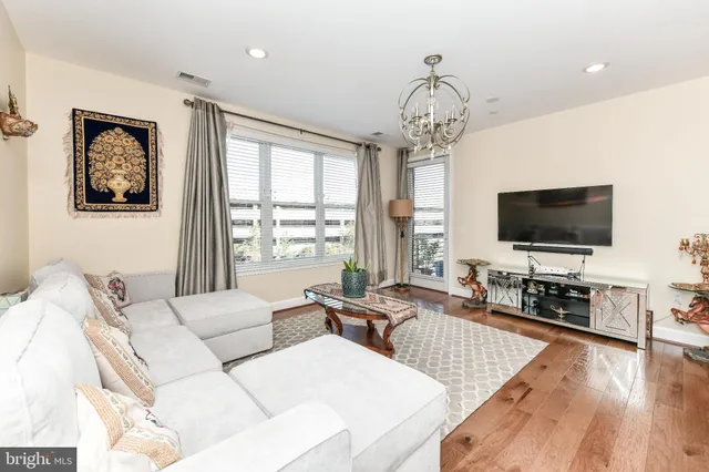 a living room with furniture a flat screen tv and a large window