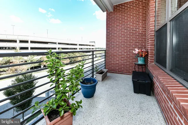 a view of a balcony with chairs potted plants