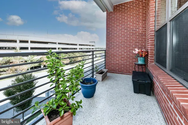 a view of a balcony with chairs potted plants