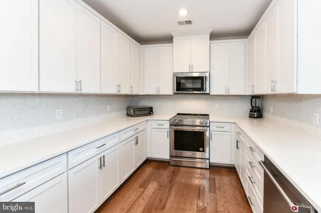 a kitchen with granite countertop white cabinets and white appliances