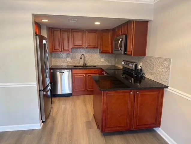 a view of an empty room with wooden floor and a ceiling fan