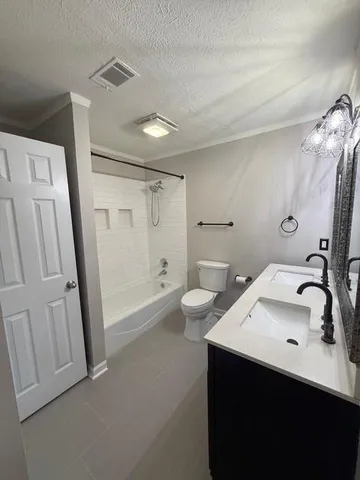 a bathroom with a double vanity sink toilet and a mirror