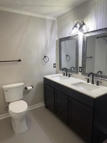 a bathroom with a sink vanity mirror and toilet