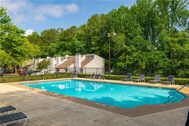 a view of a house with pool and a yard